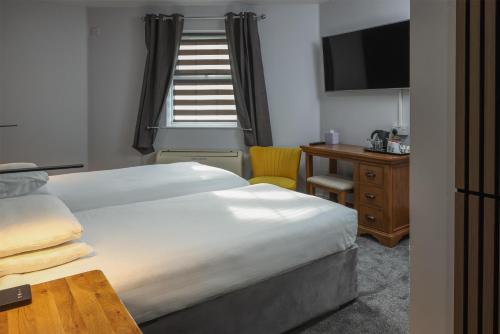 ein Hotelzimmer mit Bett, Schreibtisch und Fernseher in der Unterkunft Best Western Claydon Hotel in Ipswich