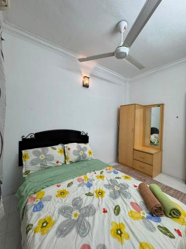 a bedroom with a bed with flowers on it at Homestay PANDAN 10 PULAU MELAKA in Malacca