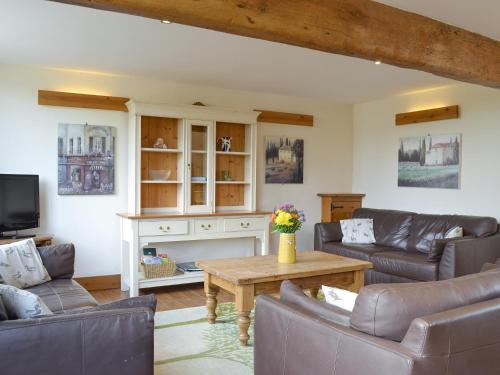 a living room with couches and a table at Four Bays - Ioh in Brandesburton
