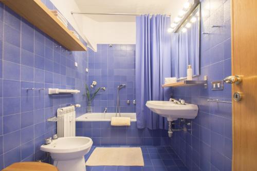 a blue tiled bathroom with a toilet and a sink at Pescasseroli Appartamento Panoramico in Pescasseroli