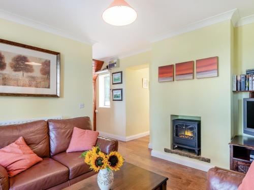 a living room with a couch and a fireplace at Edlington Hall Cottage in Edlington