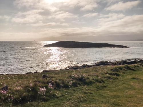a small island in the ocean on a cloudy day at Ty Bobbet in Amlwch
