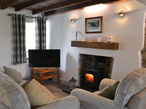 a living room with two chairs and a fireplace at Ty Bobbet in Amlwch