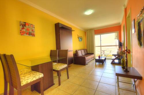 a yellow room with a waiting room with a table and chairs at Yatch Village Flat in Natal