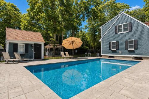 a house with a swimming pool in front of a house at Private Pool Central AC Dog Friendly in Barnstable