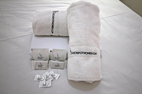 a towel on a bed with some packets of towels at Rio Spot Homes Leblon D026 in Rio de Janeiro