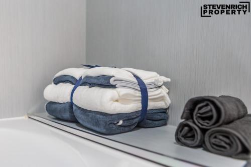 a shelf with a pile of towels on it at Newly Refurbished Flat Parking 2 Bedrooms 4 Guests in Kenton