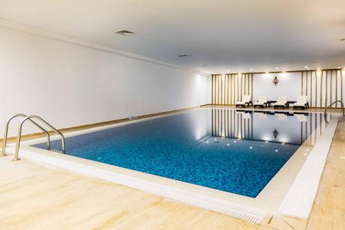 a swimming pool in a hotel with chairs and a table at Port View Hotel in Famagusta