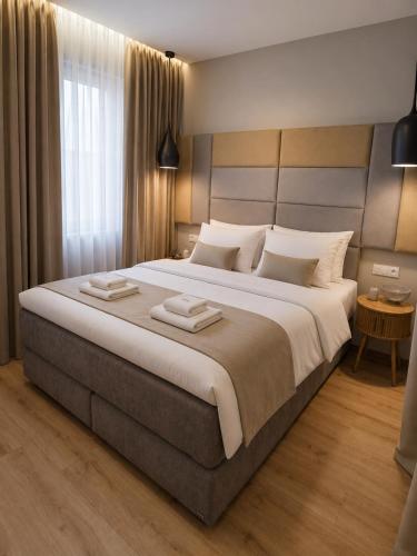 a bedroom with a large bed with two towels on it at Hotel Marathon in Senec