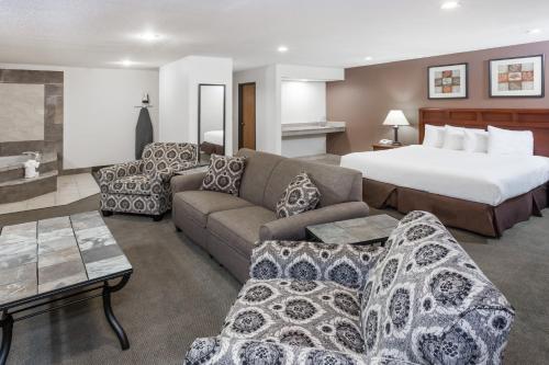 ein Hotelzimmer mit einem Bett und einem Sofa in der Unterkunft Baymont by Wyndham Tuscola in Tuscola