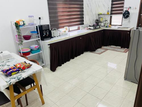 a kitchen with a counter and a table in it at Sawaddi Homestay in Bukit Payong