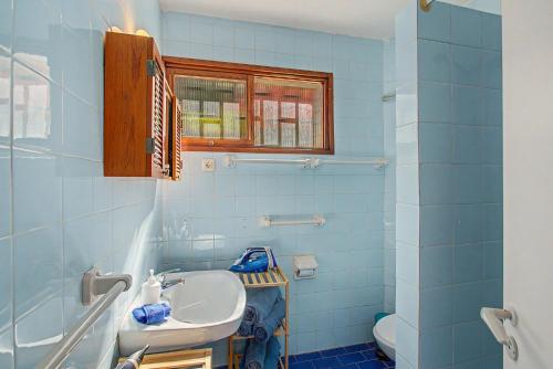 a blue bathroom with a sink and a toilet at A la Playa en San Agustín in Maspalomas