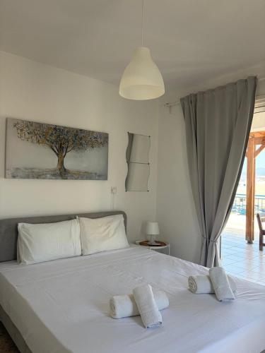 a bedroom with a white bed with towels on it at Galtheo in Lachi