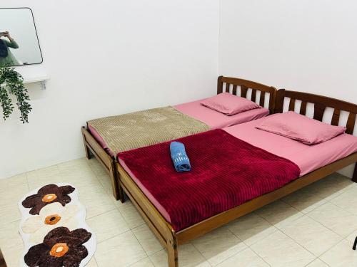 a bed with a remote control sitting on top of it at Sawaddi Homestay in Bukit Payong