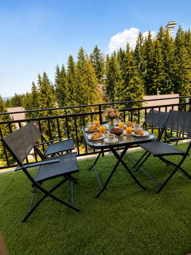 a table with a tray of food and two chairs at Monti Wellness & Spa Vlašić in Vlasic