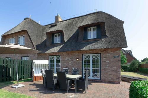 a house with a table and chairs in front of it at Alt Wrixum Haus 1 in Wrixum