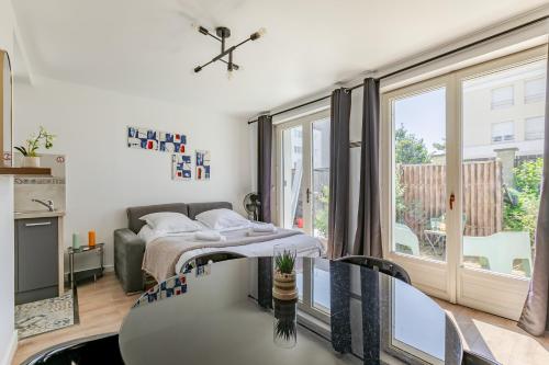 a living room with a bed and a table at Les Suites d'Orly, Évasion à 15 min de Paris in Orly