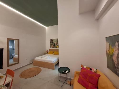 a bedroom with a bed and a couch and a table at Cosy Stay in Platamonas