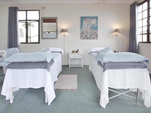 a bedroom with two beds and a mirror at Secret Sands Glenmore Beach in Port Edward