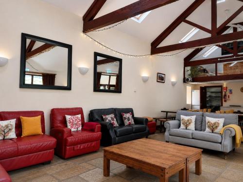 a living room with couches and a table and mirrors at Howgills Barn in Sedbergh