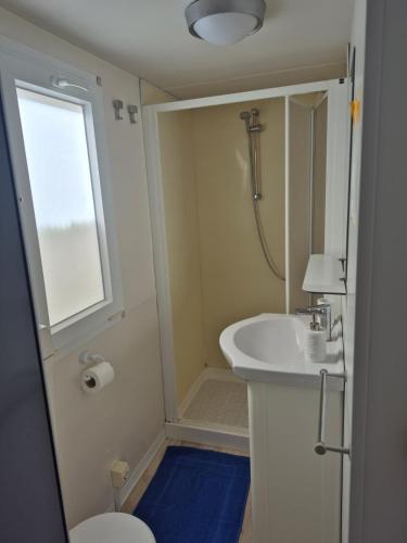 a bathroom with a sink and a toilet and a window at Al Fresco Mare in Triscina