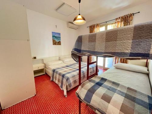 a bedroom with two beds and a bunk bed at Terraced house with garden and pool in Porto Santa Margherita di Caorle