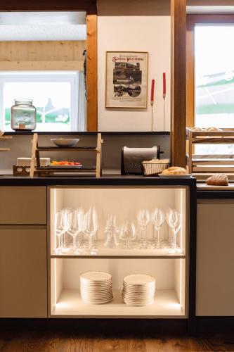 a shelf with plates and wine glasses in a kitchen at Gasthof Wachter in Gaal