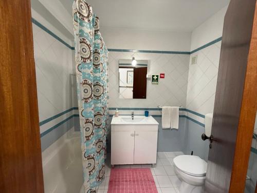 a bathroom with a toilet and a sink at Casa Fragata B in Armação de Pêra