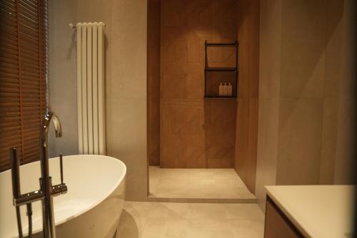 a bathroom with a bath tub and a shower at August Suites & Chalets in Khŭjakent Bekati