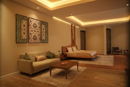 a living room with a couch and a bed at August Suites & Chalets in Khŭjakent Bekati