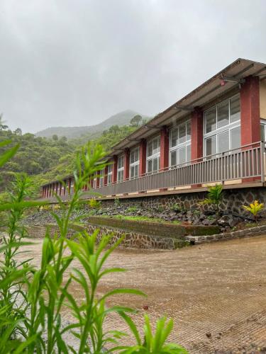a red building with windows on a mountain at Jashoda Dham Agro Tourism in Pune