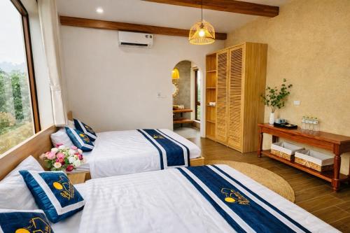 a hotel room with three beds and a table at The Windy Villa Ba Vì in Xóm Gốc Gia