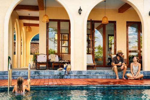 a group of people sitting in a swimming pool at The Windy Villa Ba Vì in Xóm Gốc Gia
