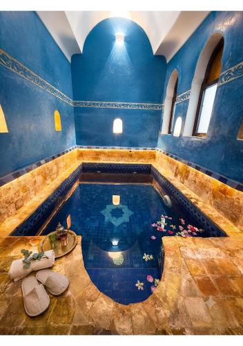 a large pool of water in a blue room at Riad ABBASSIA Marrakech Première - Authentic Medina Experience in Marrakesh