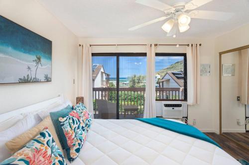 a bedroom with a bed with a ceiling fan at Central and Bright 2 BR, 2 BA, Pool and Oceanview in Lihue