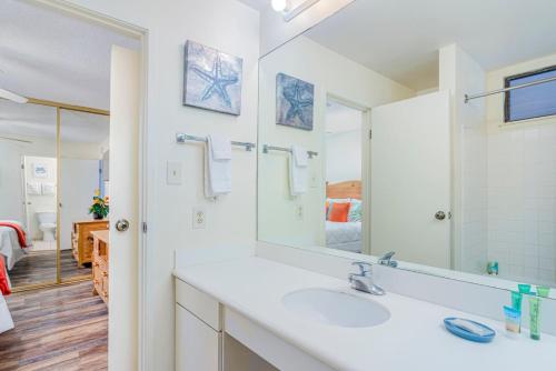 a bathroom with a sink and a mirror at Central and Bright 2 BR, 2 BA, Pool and Oceanview in Lihue