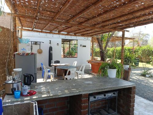 an outdoor kitchen with a brick counter and a table at Casa Rústica Diaz in Ica
