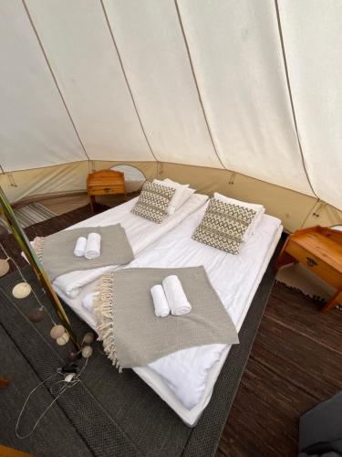 a bed in a tent with towels and pillows at Kaptenshuset B&B och Hotell in Kivik