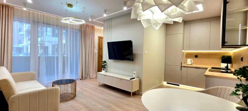 a living room with a television and a table and chairs at Apartament Dąbrowskiego in Iława