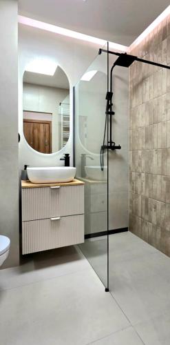 a bathroom with a sink and a mirror at Apartament Dąbrowskiego in Iława
