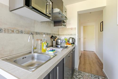 a kitchen with a sink and a counter at Les Suites d'Orly, Évasion à 15 min de Paris in Orly