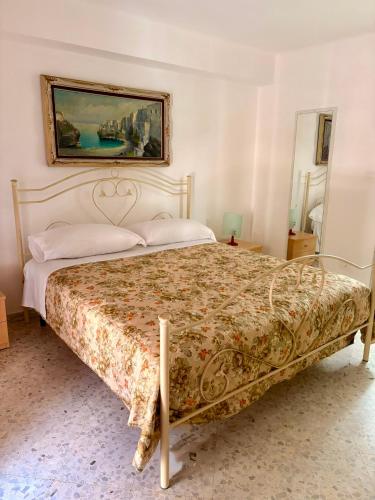 a bed in a bedroom with a painting on the wall at I Due Timidi in Putignano