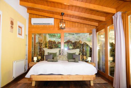 a bedroom with a bed and a large window at Erdei Kisház Sümeg in Sümeg