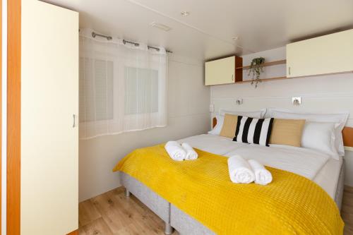 a bedroom with a bed with two towels on it at Bol Cutie in Murvica