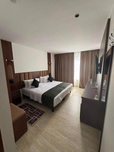 a bedroom with a bed and a desk in it at Hôtel City Center in Nador