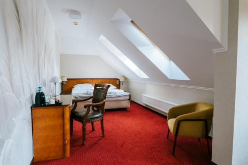 a bedroom with a bed and a table and chairs at Hotel - Dworek Tryumf in Księżyno
