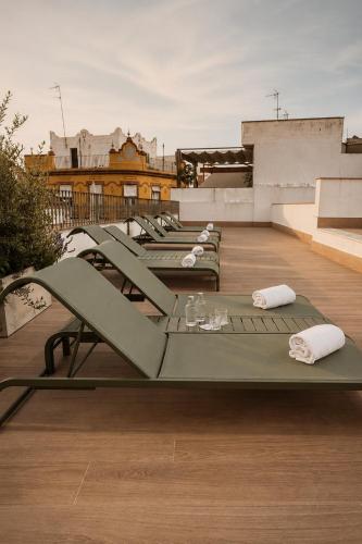 a row of lounges on the roof of a building at Mercer Residences Sevilla in Seville