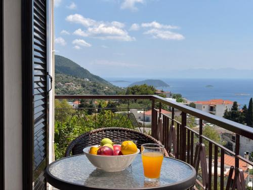 a bowl of fruit on a table with a glass of orange juice at Demie and George Ηouse in Loutraki