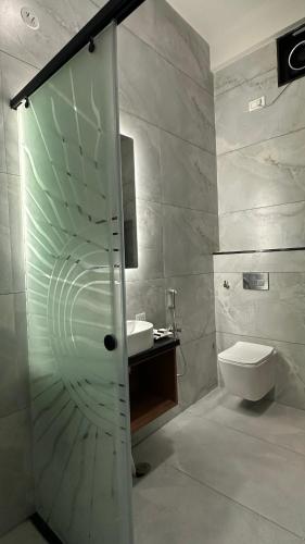 a bathroom with a shower and a sink and a toilet at Aadyanta in Kadūr
