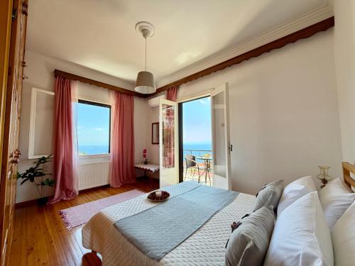 a bedroom with a bed and a view of the ocean at Demie and George Ηouse in Loutraki